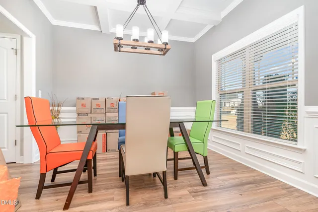 a view of a dining room with furniture a chandelier and wooden floor