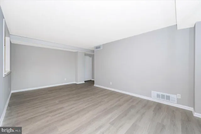 a view of an empty room with wooden floor