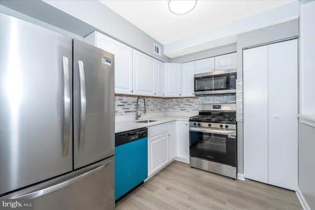 a kitchen with stainless steel appliances a refrigerator stove and sink
