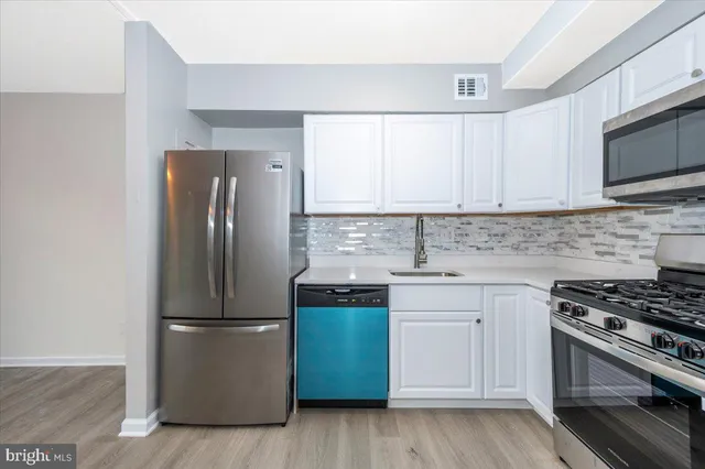 a kitchen with a refrigerator sink and stove top oven