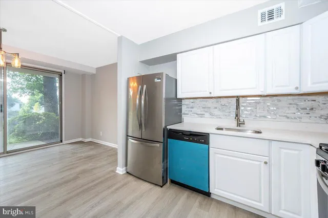 a kitchen with a refrigerator sink and cabinets