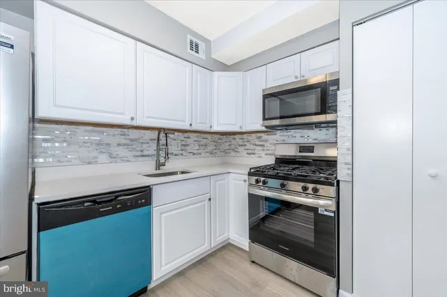 a kitchen with stainless steel appliances granite countertop a stove microwave and sink