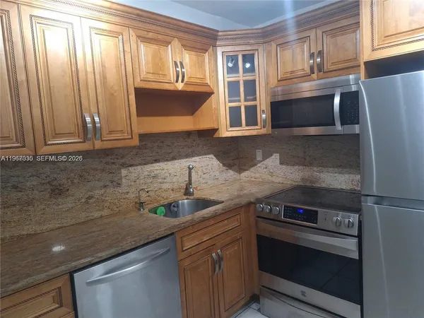 a kitchen with granite countertop stainless steel appliances and cabinets