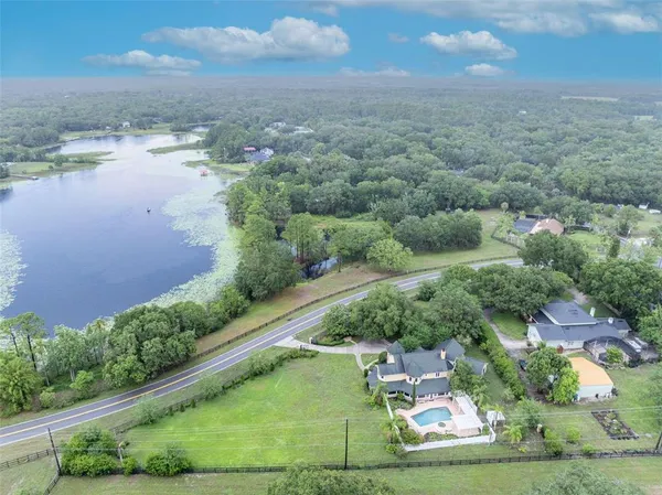 an aerial view of a house with a yard and lake view