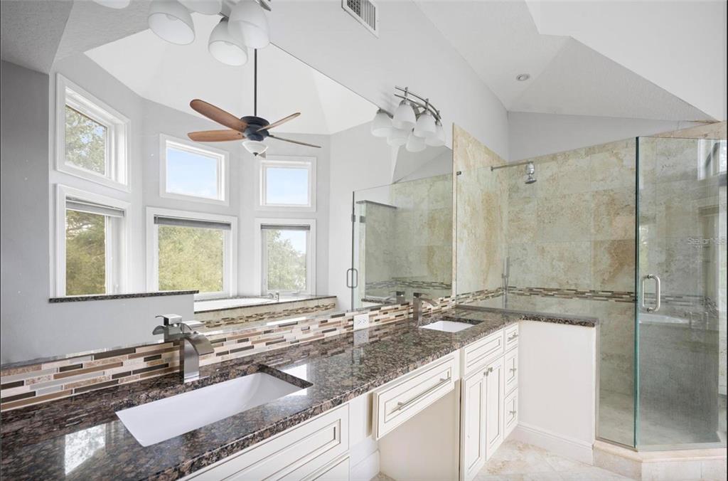 1415 Brumley Road Chuluota, FL 32766 - Photo 10 of 46 a bathroom with a granite countertop double vanity sink a mirror and a shower