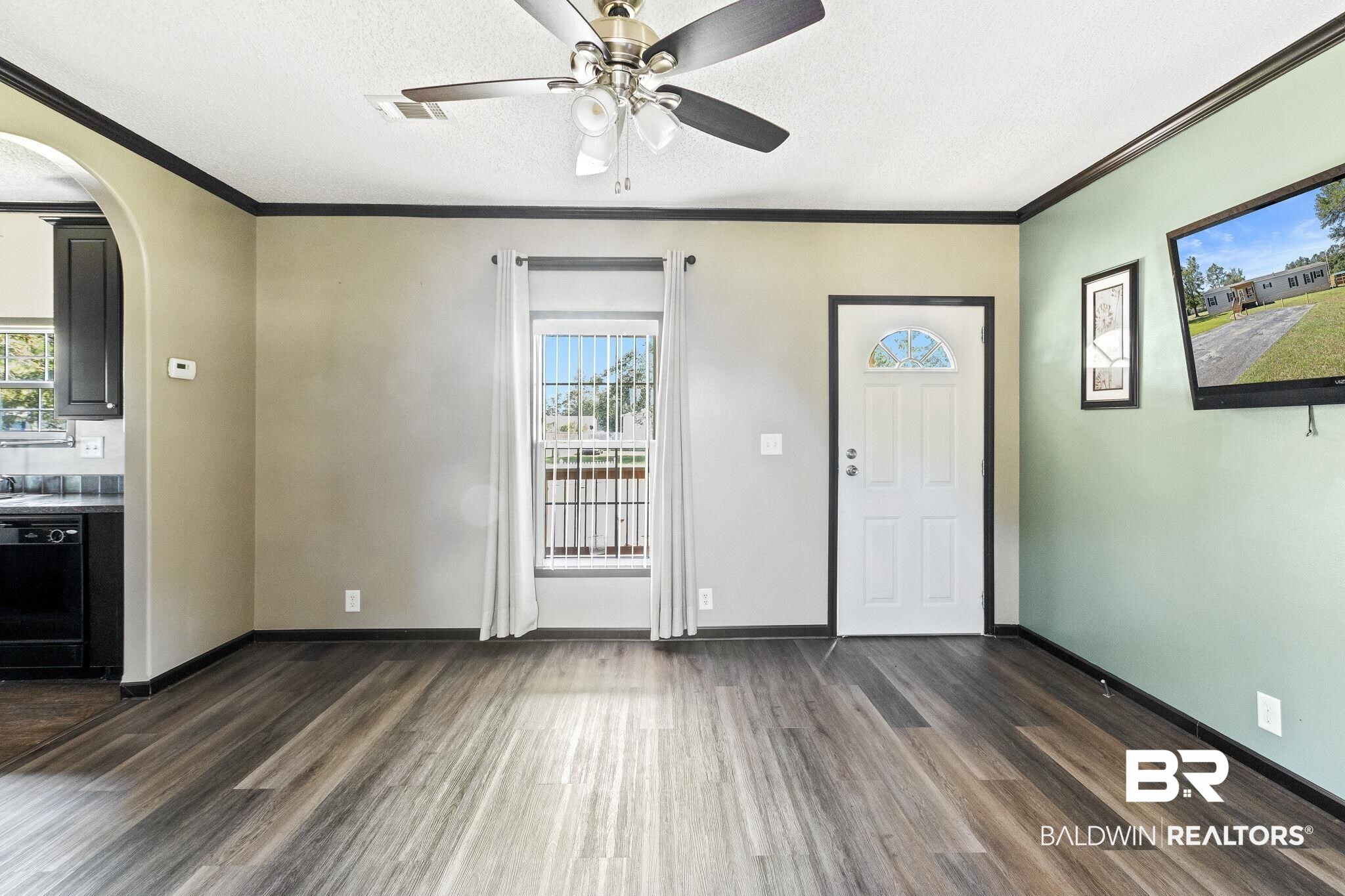 6870 Cecilia Court Theodore, AL 36582 - Photo 16 of 83 Entryway featuring dark wood-type flooring, plenty of natural light, ornamental molding, and a textured ceiling