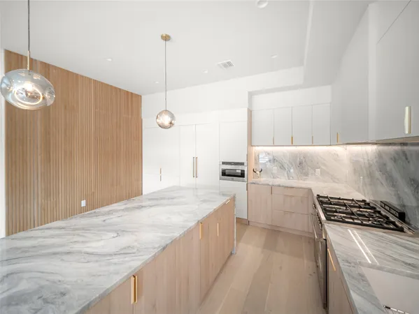 a kitchen with a stove a refrigerator a sink dishwasher with a dining table and chairs