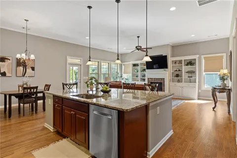 a sink with granite countertop wooden cabinets