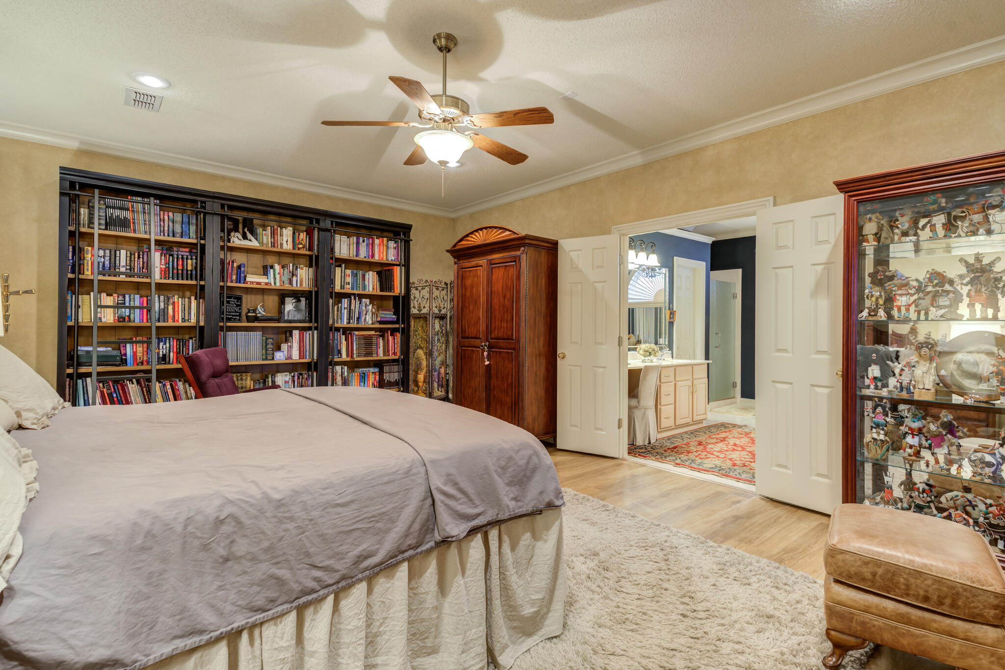 30 West Lakeshore Drive Ransom Canyon, TX 79366 - Photo 31 of 59 a spacious bedroom with a large bed a chandelier and a book shelf