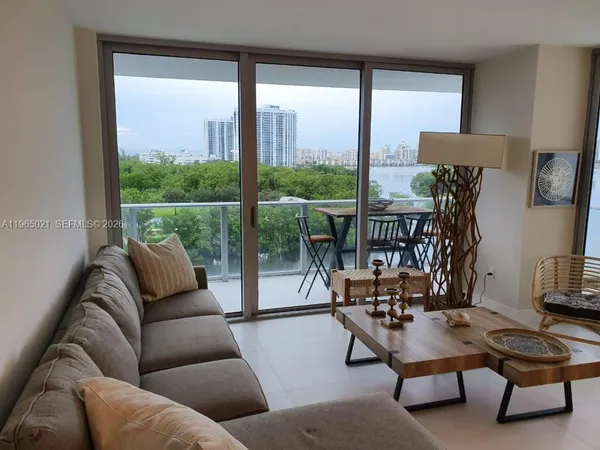 a living room with furniture a rug and a large window
