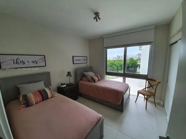 a bedroom with two beds and a large window