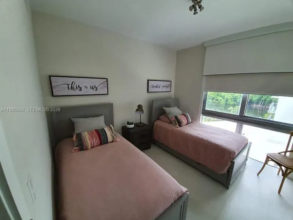 a bedroom with two beds and a large window