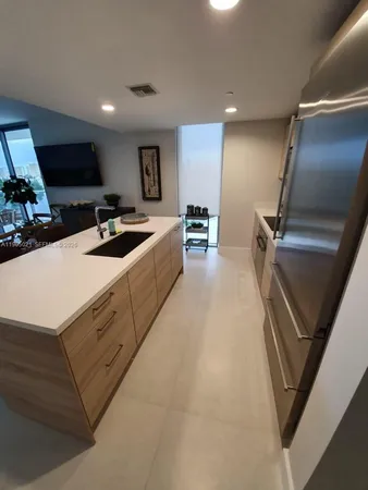a kitchen with sink refrigerator and microwave