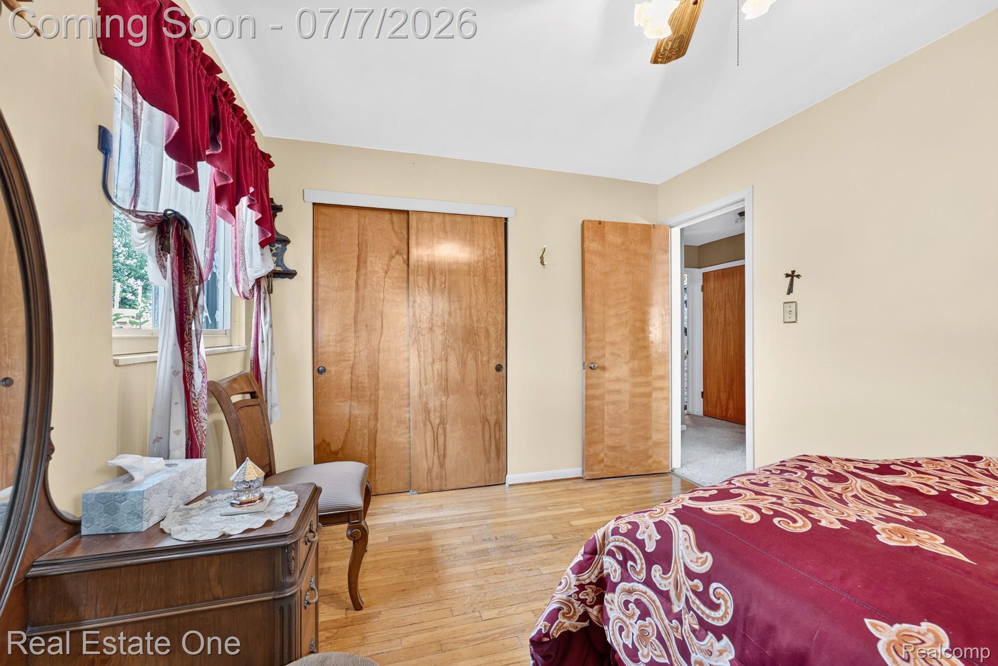 24749 Munson Street Taylor, MI 48180 - Photo 15 of 28 Warm-toned room featuring a window with natural light, wood-finish flooring, a wood-finish closet with sliding doors, and a wood-finish door