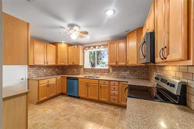 a kitchen with stainless steel appliances granite countertop a stove a sink and a microwave