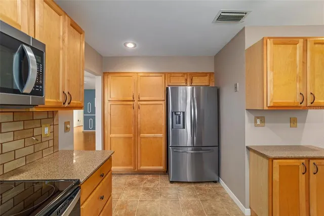 a kitchen with stainless steel appliances granite countertop a refrigerator and a stove