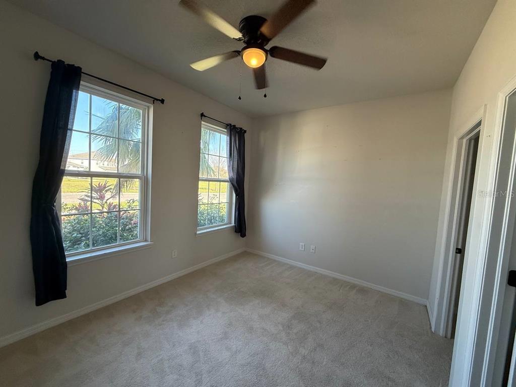14112 Poke Ridge Drive Riverview, FL 33579 - Photo 11 of 32 an empty room with windows and a ceiling fan
