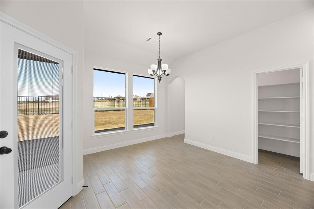 3841 Eagles Bluff Road Midlothian, TX 76065 - Photo 5 of 7 Unfurnished dining area featuring wood tiled floors, a chandelier, arched walkways, and vaulted ceiling