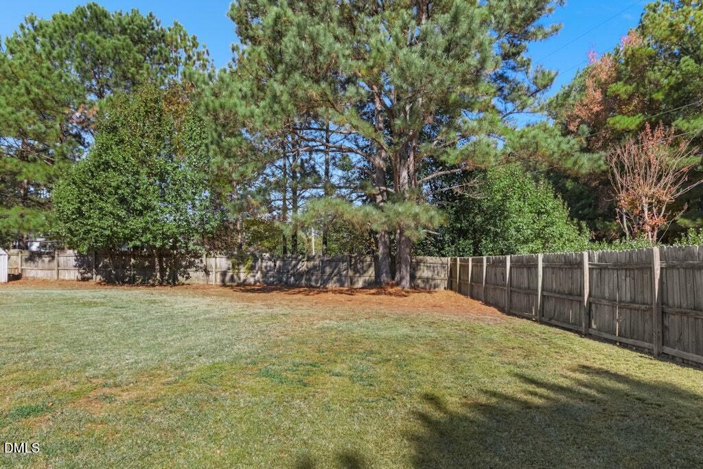 4800 Rhythm Drive Apex, NC 27539 - Photo 28 of 32 a backyard of a house with large trees and plants