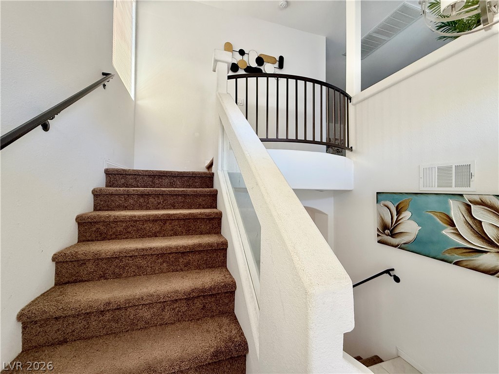7777 South Westwind Road Las Vegas, NV 89139 - Photo 44 of 46 Ascend to the upper level on plush, carpeted stairs with a graceful curved landing.