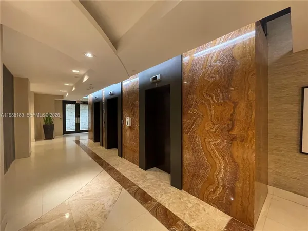 a living room with furniture potted plant and a kitchen view