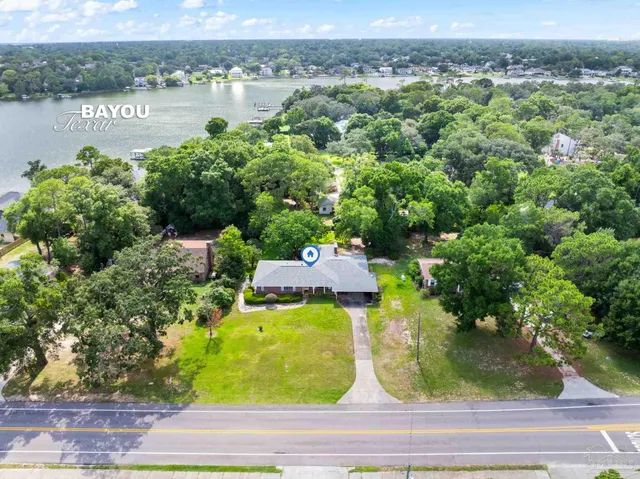 an aerial view of a house with a yard and lake view
