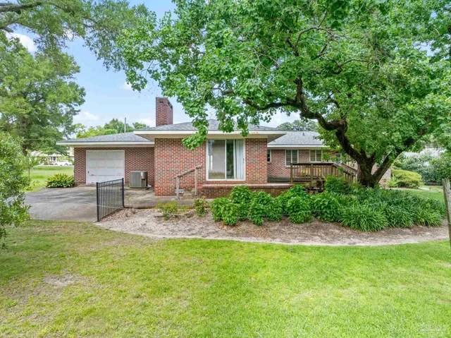 a view of a house with a yard and sitting area