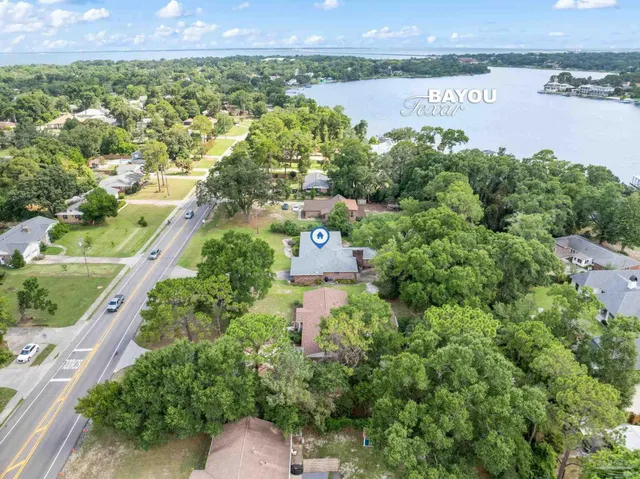 an aerial view of a house with swimming pool and large trees
