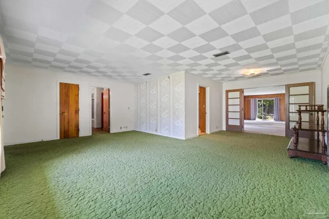 a view of an empty room with window and stairs