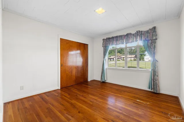 a view of a room with wooden floor and a window