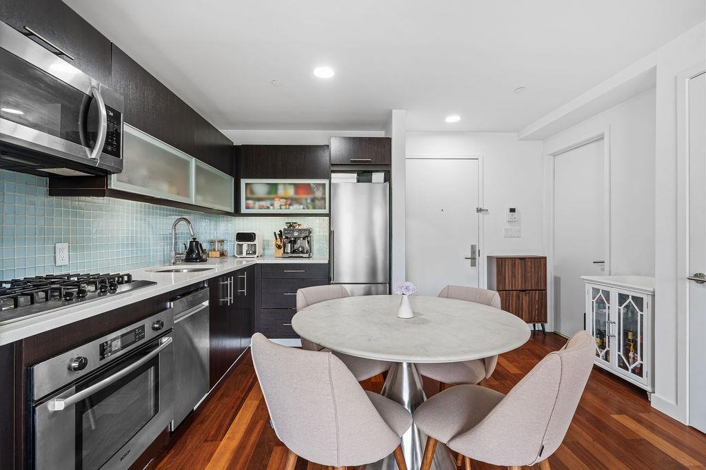 185 13th Street, Unit 3B Brooklyn, NY 11215 - Photo 4 of 8 a kitchen with stainless steel appliances a dining table chairs stove and white cabinets