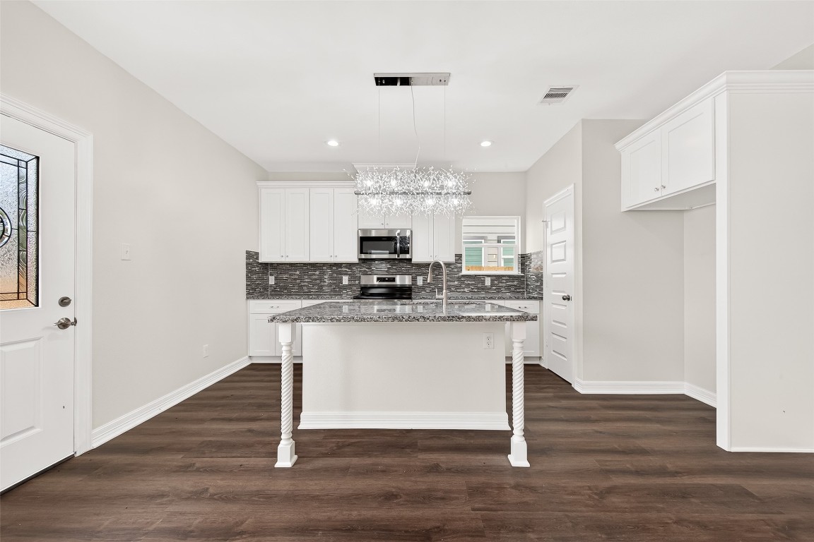 418 North 4th Street Beasley, TX 77417 - Photo 11 of 27 a kitchen with kitchen island granite countertop a sink cabinets and wooden floor