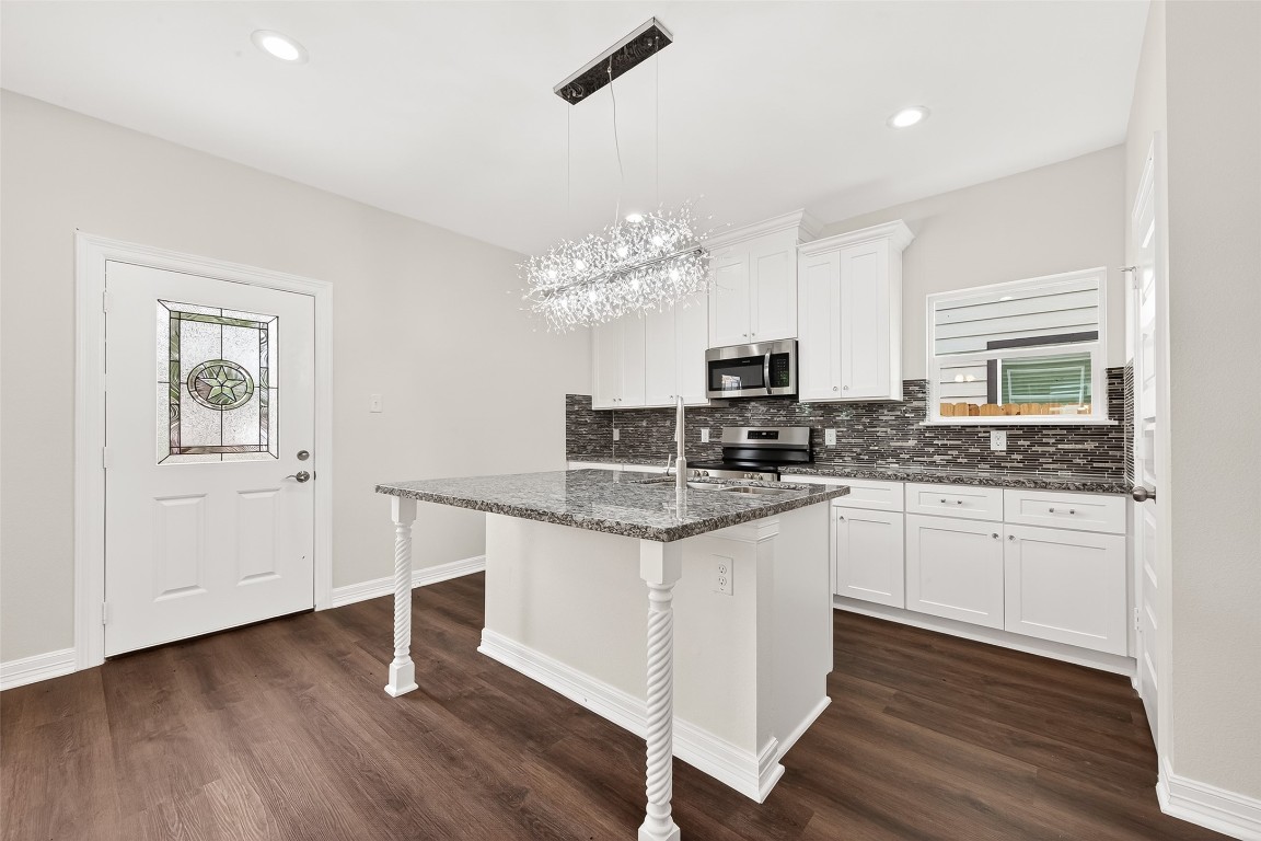 418 North 4th Street Beasley, TX 77417 - Photo 12 of 27 a kitchen with granite countertop a stove and white cabinets