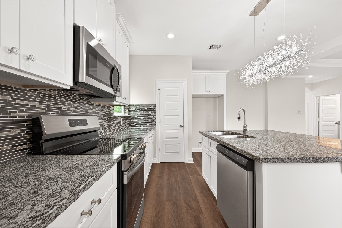 418 North 4th Street Beasley, TX 77417 - Photo 14 of 27 a kitchen with stainless steel appliances granite countertop a stove top oven a sink dishwasher and a microwave oven with white countertops