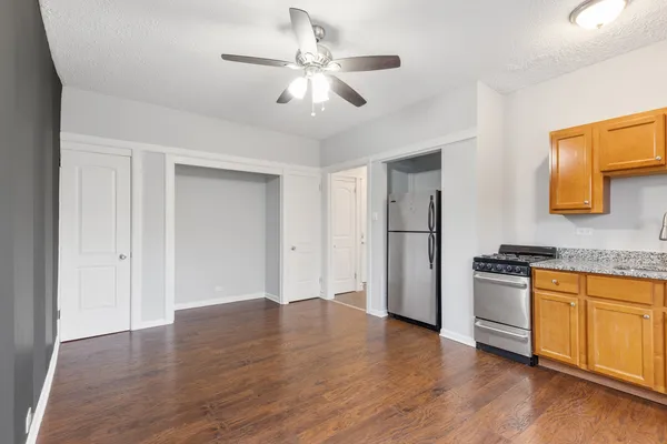 a view of a kitchen with a stove wooden cabinets and wooden floor