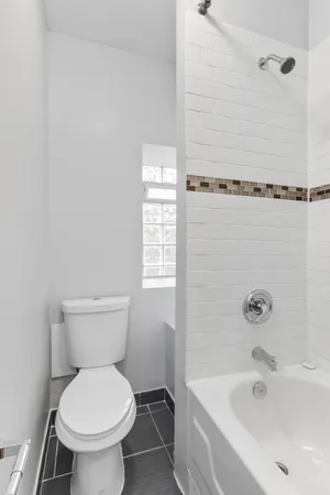 a white toilet sitting next to a bath tub