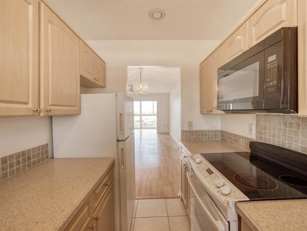 4939 Floramar Terrace, Unit 912 New Port Richey, FL 34652 - Photo 11 of 55 a kitchen with stainless steel appliances granite countertop a sink stove and cabinets