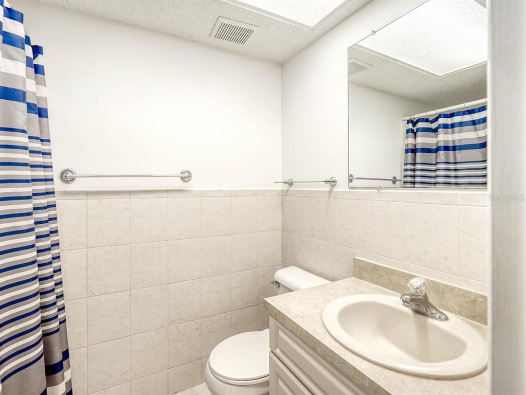 4939 Floramar Terrace, Unit 912 New Port Richey, FL 34652 - Photo 32 of 55 a bathroom with a sink toilet and shower