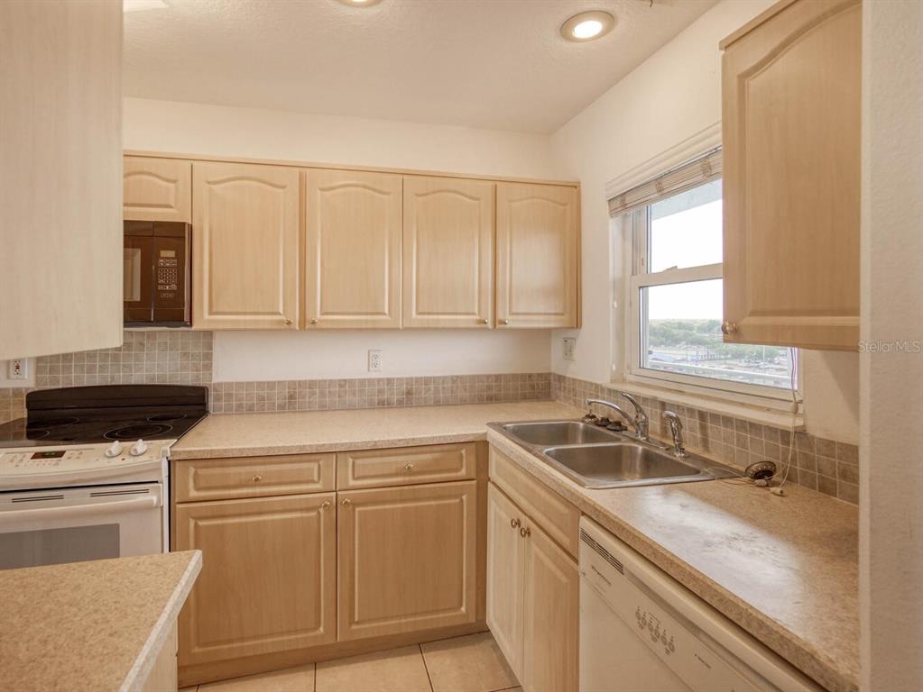 4939 Floramar Terrace, Unit 912 New Port Richey, FL 34652 - Photo 8 of 55 a kitchen with granite countertop a sink and a stove top oven