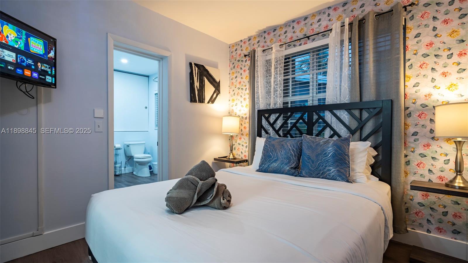 1305 Funston Street Hollywood, FL 33019 - Photo 18 of 93 a bedroom with a bed a flat screen tv and a window