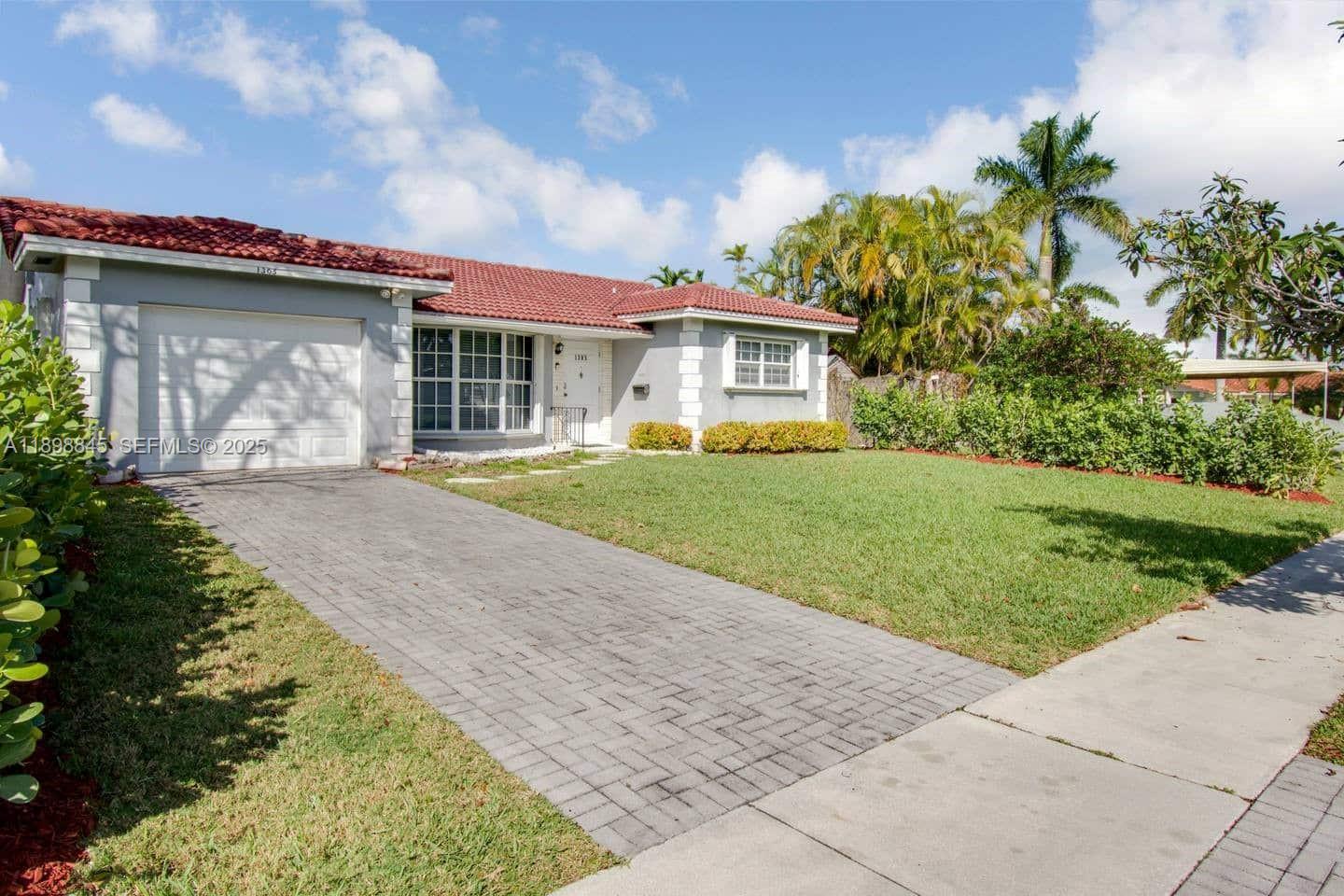 1305 Funston Street Hollywood, FL 33019 - Photo 28 of 93 a front view of a house with a garden and yard