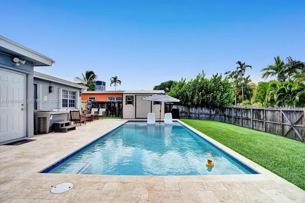 a view of a house with backyard and sitting area