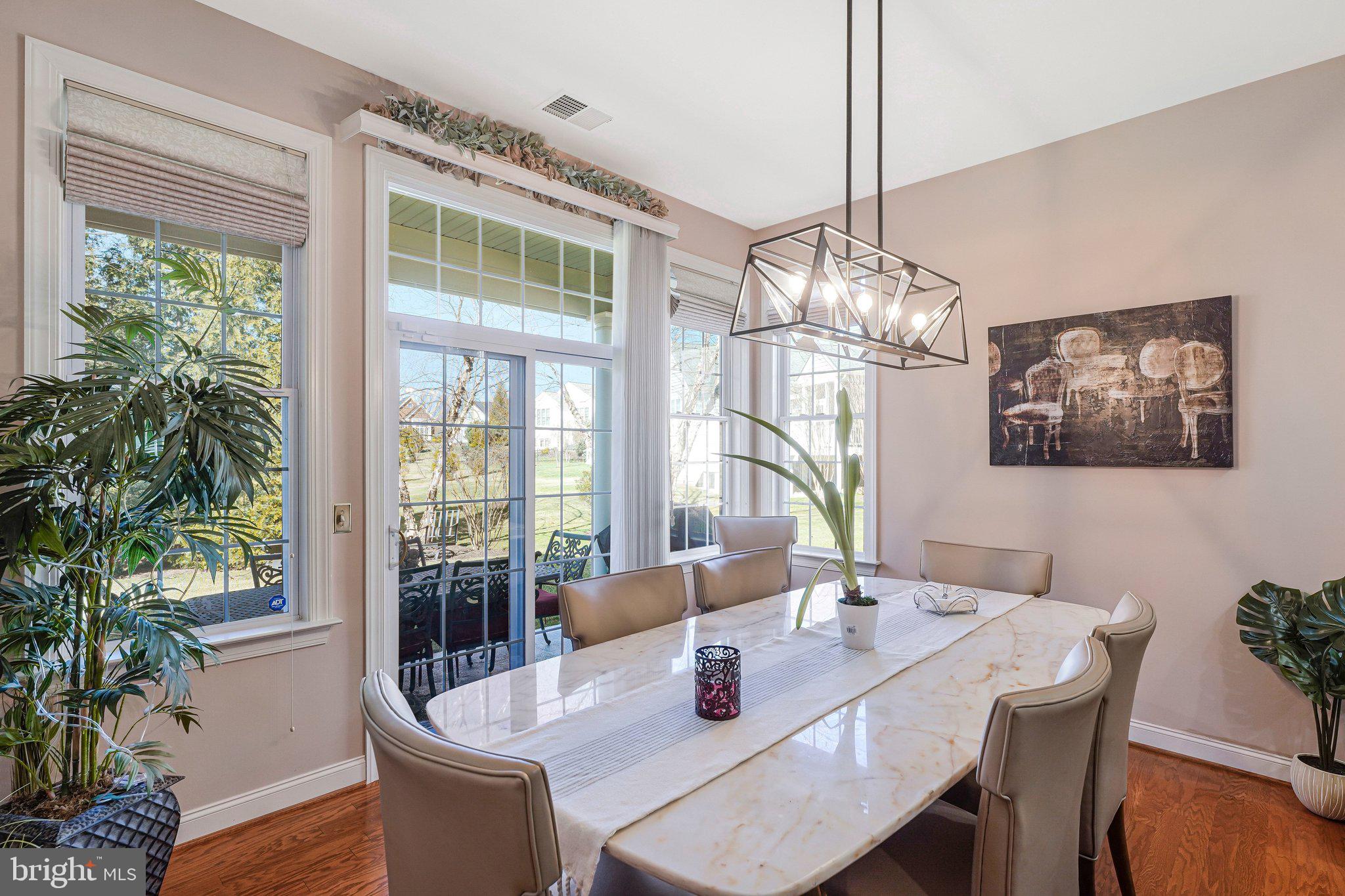 15517 Legacy Way Haymarket, VA 20169 - Photo 14 of 68 a dining room with furniture a large window and wooden floor