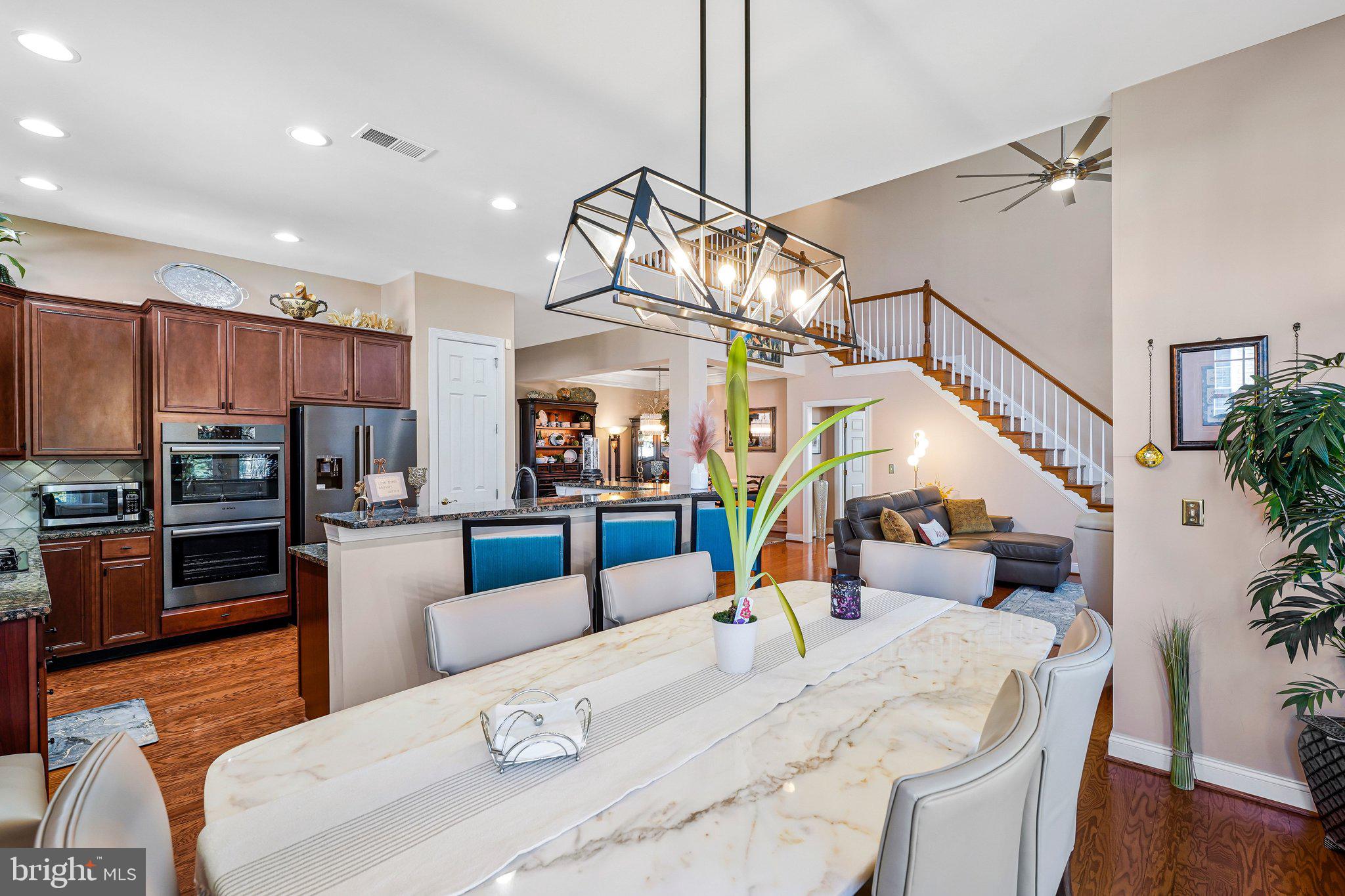 15517 Legacy Way Haymarket, VA 20169 - Photo 15 of 68 a kitchen with stainless steel appliances kitchen island granite countertop a table chairs and a refrigerator