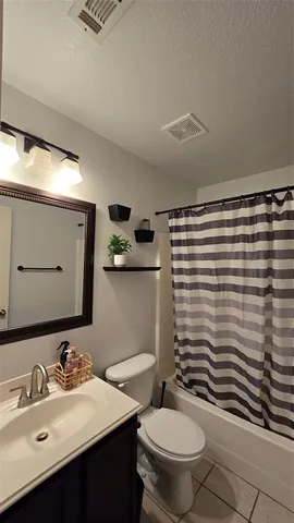 a bathroom with a sink a toilet a mirror and shower curtain