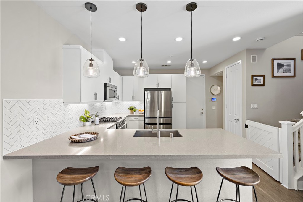 2 Agrios Street Rancho Mission Viejo, CA 92694 - Photo 3 of 29 a kitchen with a dining table chairs and white cabinets