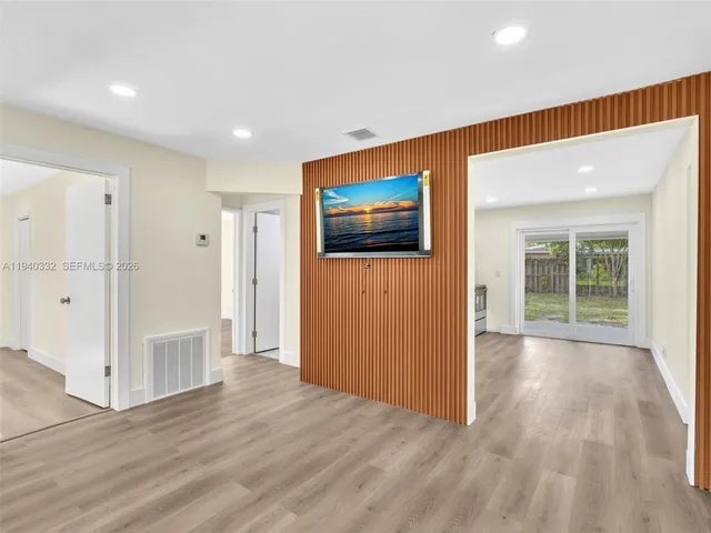 en empty room with wooden floor and windows