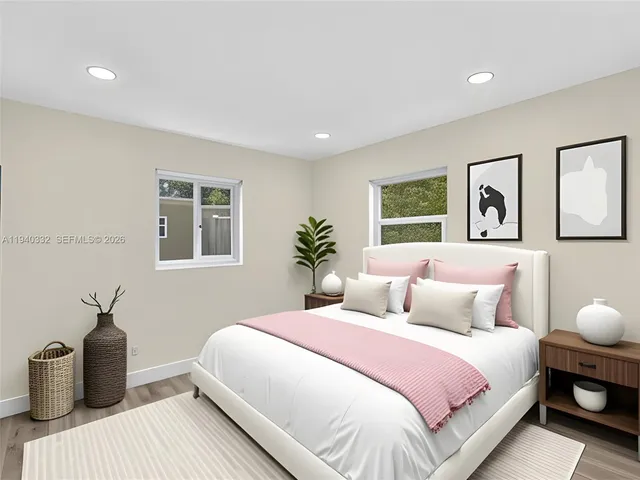 a bedroom with a large bed and a potted plant