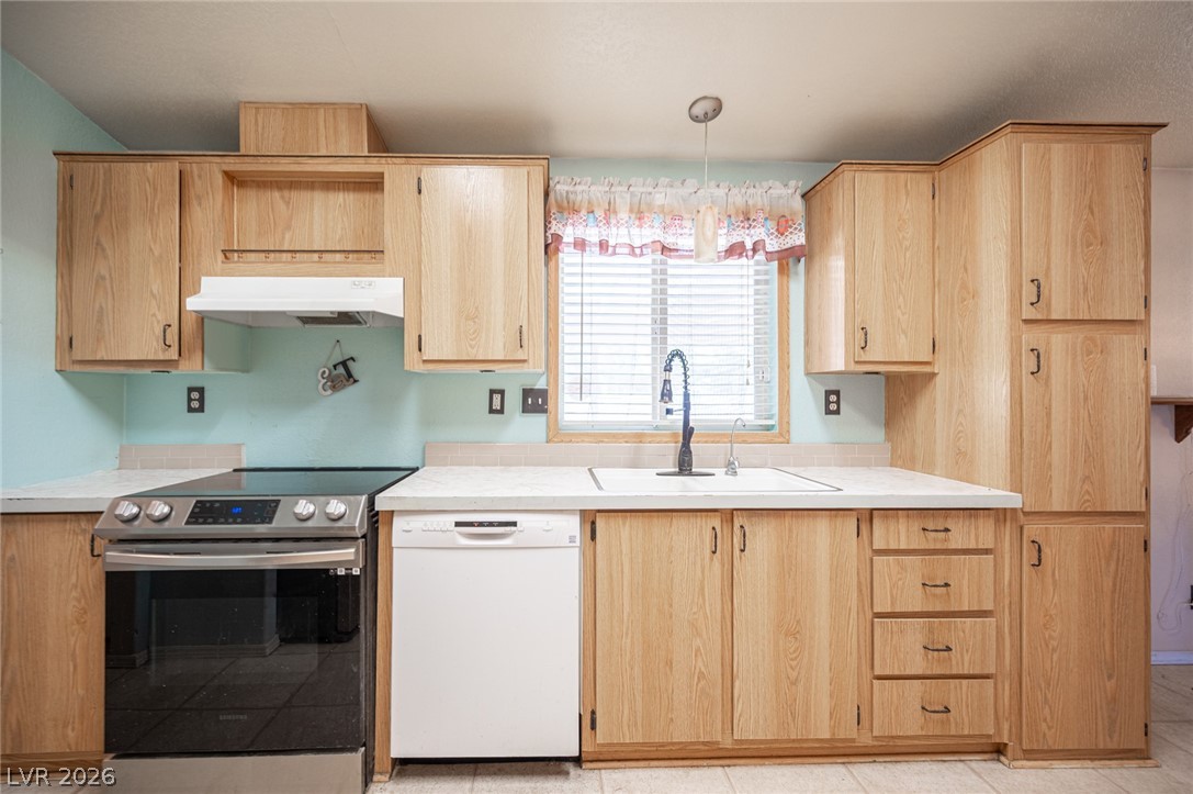 3200 Maple Road Pahrump, NV 89048 - Photo 19 of 53 A well-lit kitchen features generous wood cabinetry and functional appliances for everyday living.