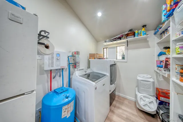 a utility room with fridge dryer and washer